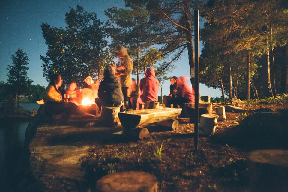 Porukka nuotiolla metsässä illalla